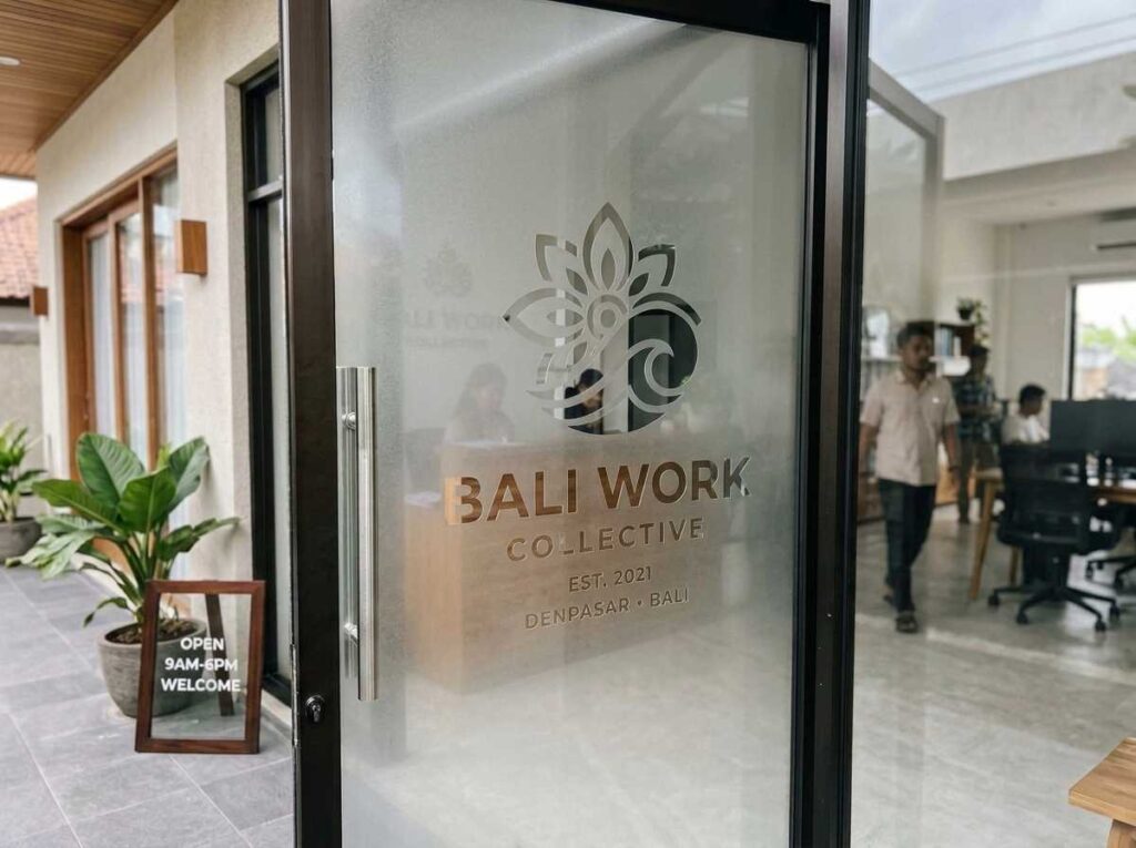 Pemasangan sticker sandblast logo presisi pada pintu kaca lobi kantor di Bali.